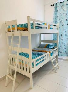 Litera blanca con escalera en una habitación en Brand New Cozy home Desaru Pengerang near Sebana Cove Resort en Pengerang