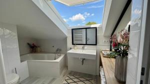 ein Badezimmer mit einem Waschbecken, einer Badewanne und einem WC in der Unterkunft Hotel Victoria in Dinslaken