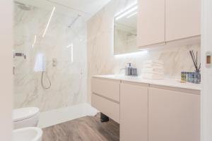 bagno bianco con servizi igienici e lavandino di Modern & Stylish Apartment in Como City by Rent All Como a Como