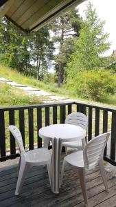 a white table and two chairs on a deck at Les Chalets d'Aurouze, La joue du loup in Le Dévoluy