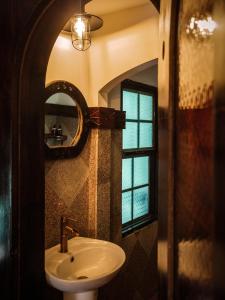 Y.O Inn في Kon Tum: حمام مع حوض ومرآة ونافذة