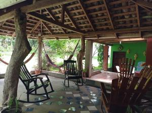 a room with chairs and a table and a tree at Loren's house in Moyogalpa
