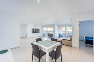 ein Wohnzimmer mit Tisch, Stühlen und Sofa in der Unterkunft Premium apartment in Benidorm