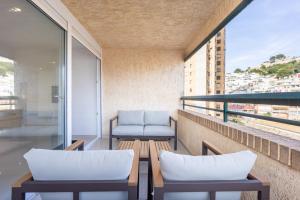 ein Balkon mit zwei Stühlen und Tischen an einem Gebäude in der Unterkunft Premium apartment in Benidorm