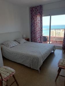 een slaapkamer met een bed en uitzicht op de oceaan bij Magnifique vue à 100m de la plage in Benalmádena