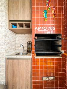 uma cozinha com um forno e um lavatório em LINDO NOVISSIMO e PÉ NA AREIA em Bertioga