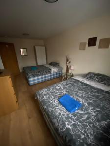 - une chambre avec 2 lits et un dossier bleu dans l'établissement BIG ROOM rusholme WITH TV AND PRIVATE BATHROOM-parking&wifi, à Manchester