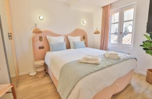 sypialnia z dużym białym łóżkiem z ręcznikami w obiekcie CMG - Appartement rénové - 2BR/6p - Hyper centre St Tropez w Saint-Tropez