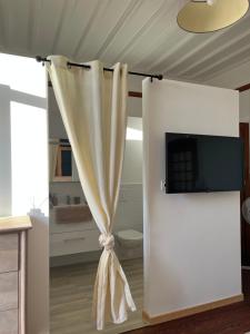 a white curtain in a room with a tv at O'Cottage double in Annonay