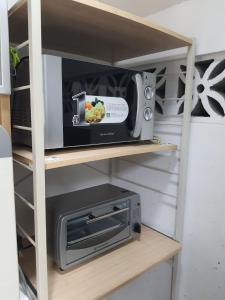 microondas y tostadora en un estante en La Sierra Guest House, en Manbiga
