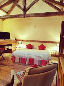 ein Schlafzimmer mit einem Bett und einem Sofa in einem Zimmer in der Unterkunft Hôtel Les Orangeries in Lussac-les-Châteaux
