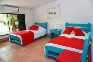 a bedroom with two beds with red and blue at Casa Antigua in San Silvestre