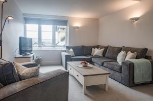 a living room with a couch and a tv at Minarvon - 2 Bedroom Apartment - Saundersfoot in Saundersfoot