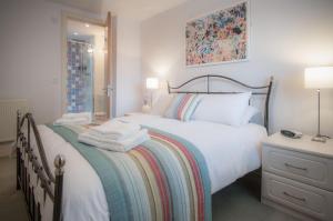Minarvon - 2 Bedroom Apartment - Saundersfoot في ساندرزفوت: غرفة نوم عليها سرير وفوط
