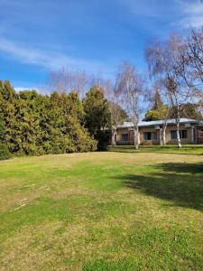 a large yard with a house in the background at VILLAGE PARK in Tandil