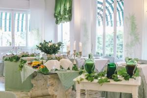 a dining room with tables with flowers and candles at Eveline Portosole Hotel in Sanremo