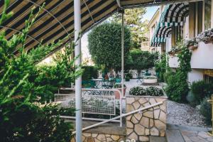 a garden with a table and chairs and plants at Eveline Portosole Hotel in Sanremo