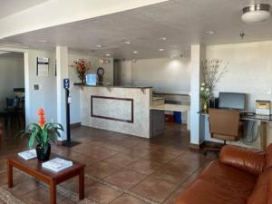 een woonkamer met een bank en een tafel bij Motel 6 Riviera Beach FL in Riviera Beach