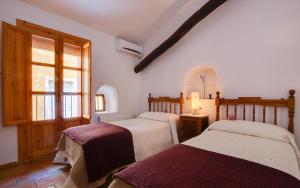 - une chambre avec 2 lits et une fenêtre dans l'établissement Casa rural Plaza Vieja en Bullas, à Bullas