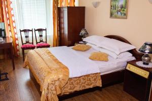 a bedroom with a large bed with two chairs at Vila Muntenia Hotel in Chişinău