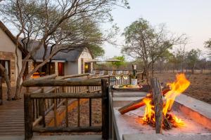 a fire pit in front of a house at Vuyani Marula Lodge in Hoedspruit