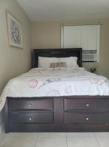 ein Schlafzimmer mit einem großen Bett mit einem Holzrahmen in der Unterkunft Entire Guesthouse 5 mins to Siesta Key & downtown in Sarasota