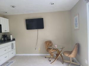 ein Esszimmer mit einem Glastisch und 2 Stühlen in der Unterkunft Entire Guesthouse 5 mins to Siesta Key & downtown in Sarasota
