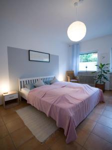 a bedroom with a large bed with a pink blanket at Ferienwohnung auf dem Kore in Kirkel