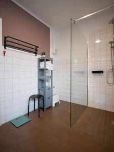 a bathroom with a glass shower and a stool at Ferienwohnung auf dem Kore in Kirkel +19 photos