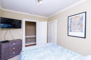 a bedroom with a bed with a dresser and a tv at Downtown Annapolis King George 3rd Floor Hideaway in Annapolis