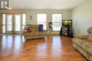 a living room with two couches and a flat screen tv at Lakeshore Guest House - sleeps 18 in Sylvan Lake