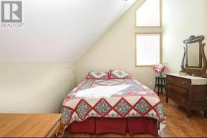 a bedroom with a bed and a dresser and a window at Lakeshore Guest House - sleeps 18 in Sylvan Lake