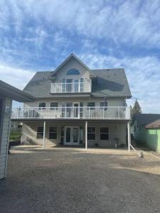 a large white house with a large porch and balcony at Lakeshore Guest House - sleeps 18 in Sylvan Lake