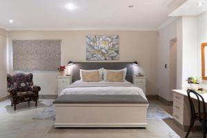Rueby’s Guesthouse في دولستروم: غرفة نوم بسرير كبير وكرسي