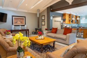 a living room with couches and a table at Rueby’s Guesthouse in Dullstroom