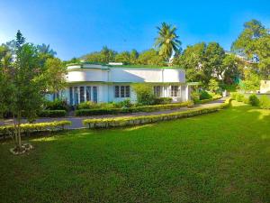 une maison avec une pelouse verte devant elle dans l'établissement Fortuna Heritage Home, à Kandy