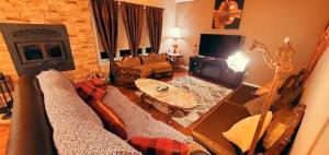 uma sala de estar com um sofá e uma televisão em Amazing 3-bedroom entire Chalet-Sauna+lakeview+Spa+BBQ(Best place to relax) em Saint Come