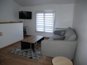 ラ・ロッシュ・シュル・ヨンにあるAppartement T2, au calme.のソファとコーヒーテーブルのあるリビングルーム