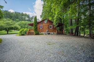 a cabin in the woods with a gravel driveway at Twin Creeks Cabin - Anglers Retreat! in Powderhorn Mountain