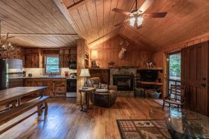 a living room with a ceiling fan and a kitchen at Twin Creeks Cabin - Anglers Retreat! in Powderhorn Mountain