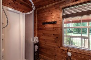 a bathroom with wooden walls and a window at Twin Creeks Cabin - Anglers Retreat! in Powderhorn Mountain