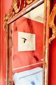 a mirror with a reflection of a bird on a wall at Casa degli Artisti in Citerna