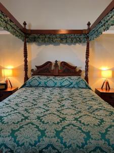 a bedroom with a bed with a blue and white bedspread at The Corrie Hotel in Corrie