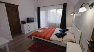 a bedroom with a bed and a dresser and a television at Aqualina Colibita in Colibiţa