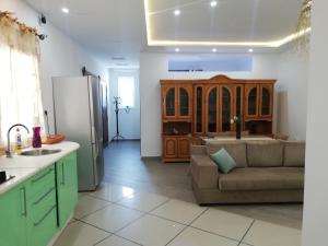 eine Küche und ein Wohnzimmer mit einem Sofa und einem Kühlschrank in der Unterkunft Fufa Apartment in Monastir