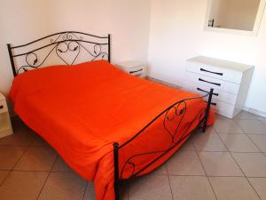 a bed with an orange comforter in a bedroom at Residence Ionian Gallipoli in Gallipoli