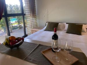 Cette chambre comprend un lit avec un bol de fruits et des verres à vin. dans l'établissement YOUR HOME in FLORENCE - Private swimming pool and Turkish bath, à Florence