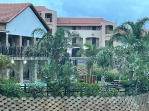a large building with palm trees in front of it at Ocean View Villas D3 in Port Edward