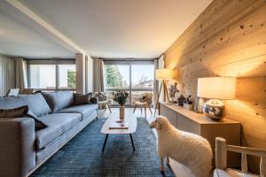 a living room with a couch and a table at Apartment Cortirion Megeve - by EMERALD STAY in Megève