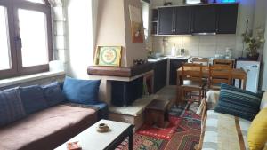 a living room with a couch and a kitchen at Arachova Houses-Ευήλιον ΛΙΒΑΔΙ in Arachova